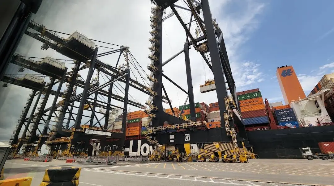 Grúas pórtico de DP World Caucedo junto a un buque portacontenedores, vistas desde la cabina de un camión